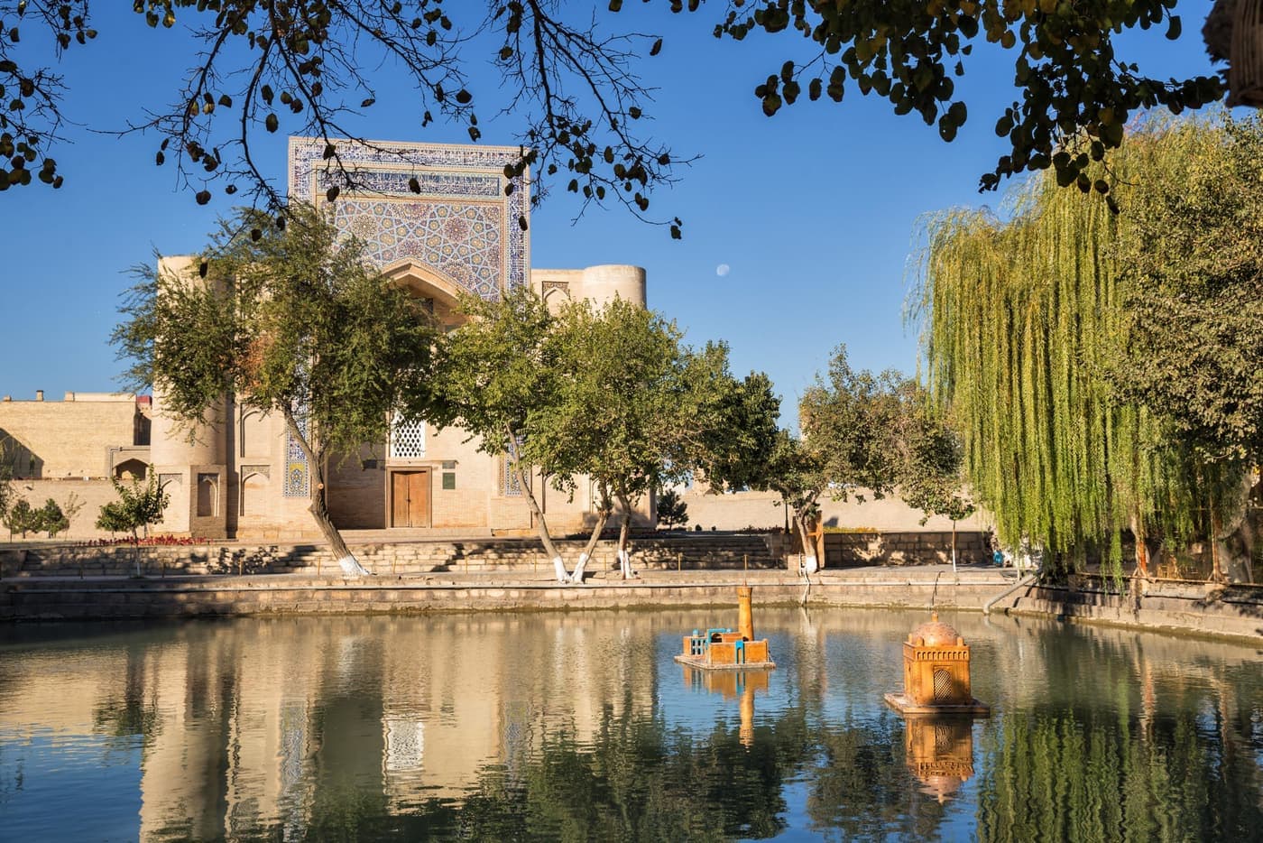 The Lyabi-Hauz pond in autumn with the Nadir Divan-Begi Khanqah behind it