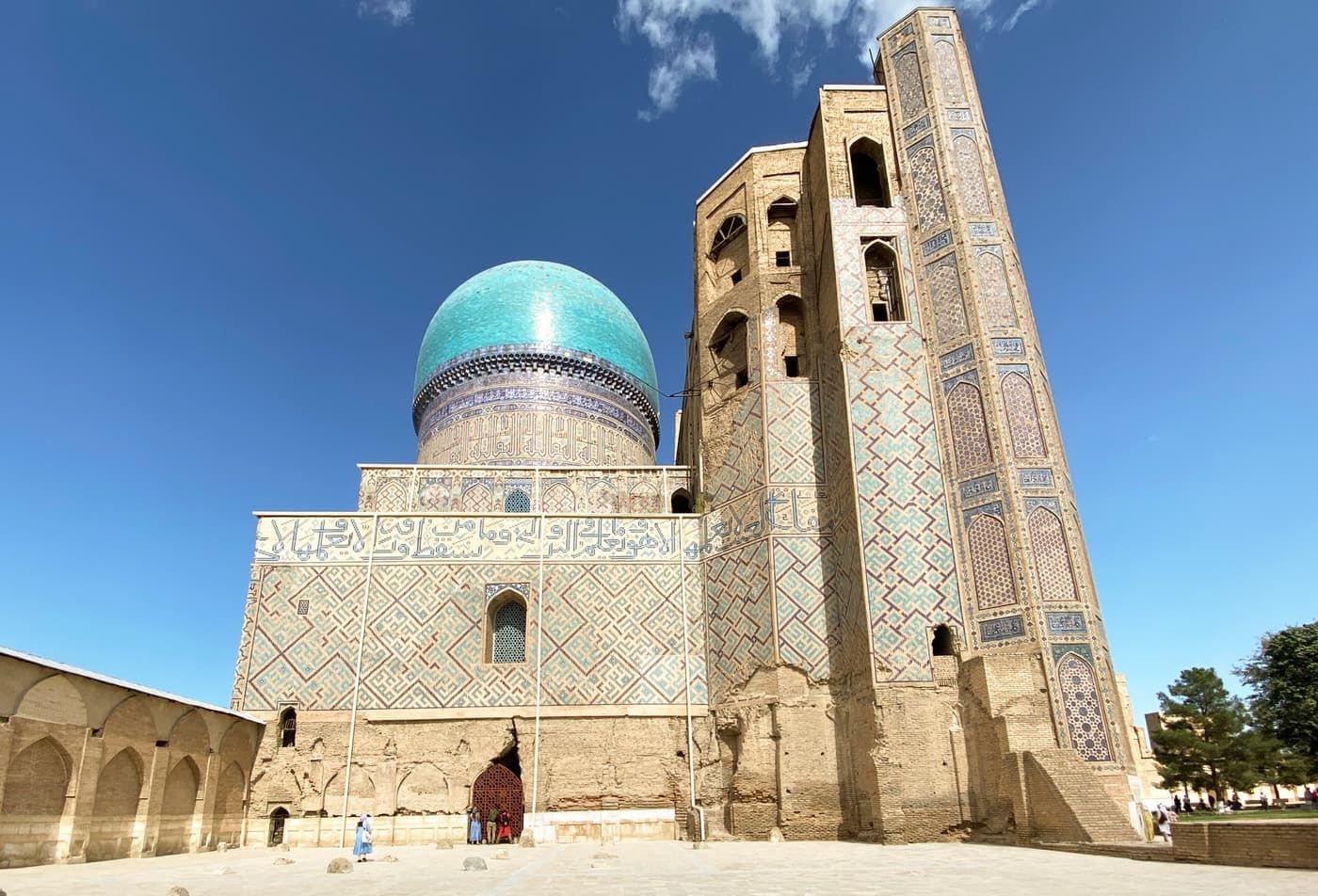The western hall of the Bibi-Khanym Mosque: a tall portal in front of a turquoise dome