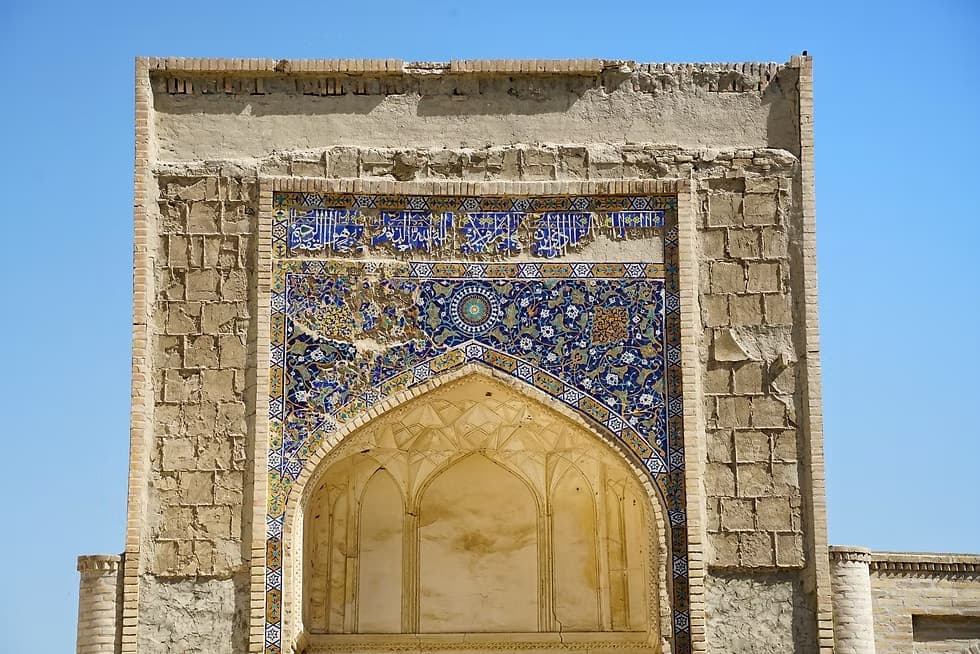 Weathered mosaic and calligraphy on a Chor-Bakr portal