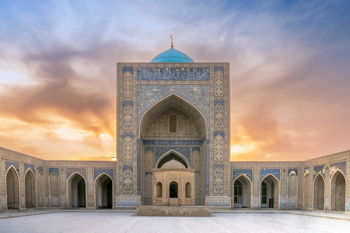 The mosque courtyard at sunset, arcades running along all four sides