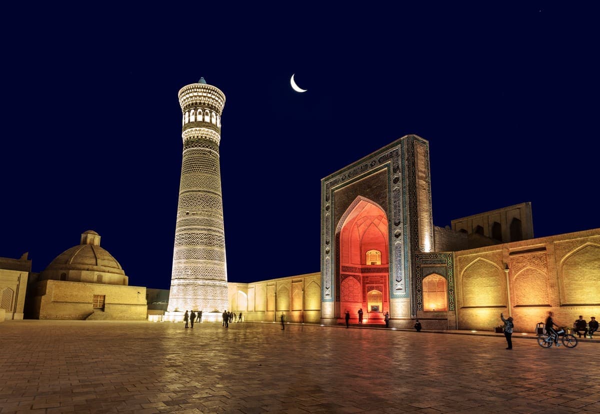 The Poi-Kalyan square floodlit at night under a crescent moon